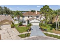 Charming two-story home with a well-maintained lawn, lush landscaping, and a spacious driveway at 1204 Rinkfield Pl, Brandon, FL 33511