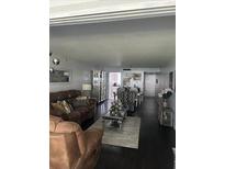 Inviting living room with comfortable leather seating, dark hardwood floors, and bright natural light at 1220 57Th N St # 103C, St Petersburg, FL 33710