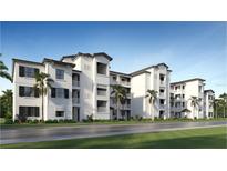 Elegant three-story condo building featuring white stucco facade, dark shutters, and private balconies offering a modern living experience at 19014 Scallop Loop # 105, Lakewood Ranch, FL 34202
