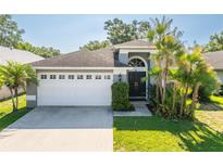 Charming single Gathering home featuring a gray exterior, well-manicured lawn, and a two-car garage at 2024 Glen Forge St, Brandon, FL 33511