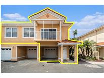 Charming two-story townhome featuring a balcony, tiled roof, and attached garages in a well-maintained community at 21007 Sunpoint Way # 203, Lutz, FL 33558