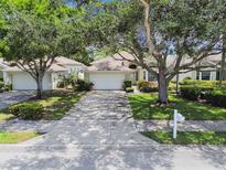 Charming one-story home with a two-car garage, driveway, mature trees and manicured landscaping at 2216 Evans Rd, Clearwater, FL 33763
