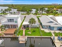 Waterfront home featuring a dock, canal access, lush landscaping, and a rooftop deck at 4012 Marine Pkwy, New Port Richey, FL 34652