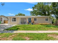 Charming single-story home features a well-manicured lawn, blue door, and inviting curb appeal at 4701 W Wyoming Ave, Tampa, FL 33616