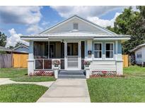 Charming single-story home with a screened-in porch and well-maintained front yard with flower garden at 508 N Walker St, Plant City, FL 33563
