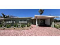 Charming single-story home with a covered carport and a beautifully paved brick driveway at 6407 1St Palm Pt, St Pete Beach, FL 33706