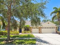 Charming single-Gathering home boasting a three car garage, stone accents and lush landscaping at 7246 Bucks Ford Dr, Riverview, FL 33578