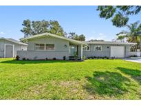 Charming one-story home with a well-manicured lawn, brick accents, and a freshly painted exterior at 94 Nicholas Dr, Dunedin, FL 34698