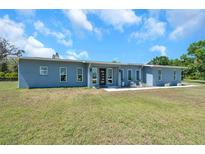 Charming single-story home featuring a modern front door, numerous windows, and manicured landscaping at 10722 Sumner Rd, Wimauma, FL 33598