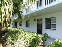 Exterior view of a well-maintained two-story condo building surrounded by lush greenery and shrubbery at 111 Lakeview Pl, Oldsmar, FL 34677