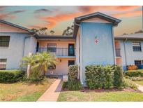 Charming two-story condo with vibrant landscaping and a welcoming entrance at 11800 Park Blvd # 208, Seminole, FL 33772