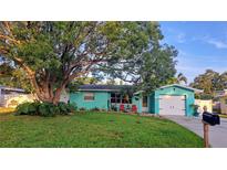 Charming home featuring vibrant curb appeal, complemented by lush landscaping and a welcoming driveway at 12176 Croft Dr, Largo, FL 33774
