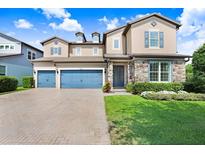 Inviting two-story home with a three-car garage, stone accents, and a manicured front lawn at 18824 Birchwood Groves Dr, Lutz, FL 33558