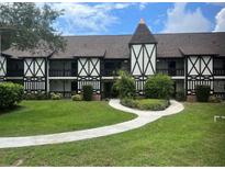 Attractive two-story condo with Tudor architecture, a manicured lawn, and a curved sidewalk at 240 N Bayshore Blvd # 102, Clearwater, FL 33759