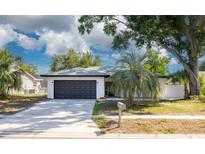 Charming single-story home with a well-maintained lawn, mature trees, and a two-car garage at 2436 Beacon Groves Blvd, Palm Harbor, FL 34683