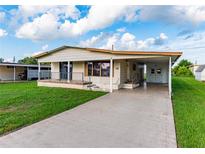 Cozy single-story home featuring a covered carport and well-maintained lawn at 5330 Jo St, Zephyrhills, FL 33542