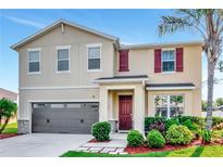 Charming two-story home with a well-manicured front yard and a modern gray garage door at 5446 Suncatcher Dr, Wesley Chapel, FL 33545
