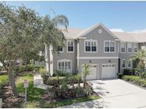 Charming townhome featuring a two-car garage, well-manicured landscaping, and a welcoming facade at 580 Shoreham Ne Ct, St Petersburg, FL 33716