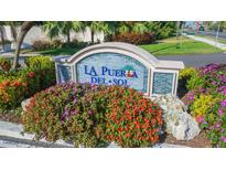 A colorful sign for 'La Puerta Del Sol' with vibrant flowers and manicured landscaping near a well-maintained street at 5825 Puerta Del Sol S Blvd # 170, St Petersburg, FL 33715