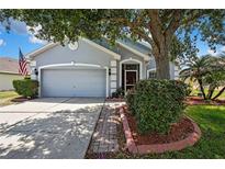Charming single-story home with mature landscaping, inviting curb appeal, and an attached two-car garage at 5925 Sweet William Ter, Land O Lakes, FL 34639