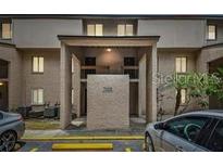 Beige two-story condo complex with covered entrance and limited parking; updated exterior and landscaping at 7523 Pitch Pine Cir # 184, Tampa, FL 33617