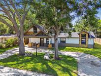 Charming craftsman home featuring a well-manicured lawn, beautiful mature trees, and unique architectural details at 816 9Th Sw Ave, Largo, FL 33770
