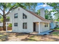 Charming home exterior showcasing a gable roof, white siding, and modern black-framed windows at 8521 N 29Th St, Tampa, FL 33604