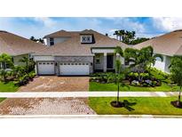 Beautiful single Gathering home with an attached three-car garage and meticulously manicured landscaping at 1028 Signet Dr, Apollo Beach, FL 33572