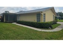 Charming single-story home featuring manicured lawn, walkway, and exterior with light yellow paint at 1107 Queen Anne Dr # C, Palm Harbor, FL 34684