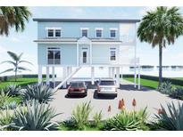Charming waterfront house on stilts featuring two cars parked in the driveway and tropical landscaping at 131 92Nd Ave, Treasure Island, FL 33706