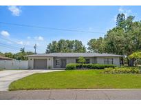 Charming single-story home with a well-manicured lawn and attached garage at 13514 Oval W Dr, Largo, FL 33774