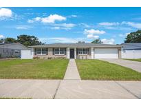 Charming single-story home featuring a well-manicured lawn and attached garage, perfect for suburban living at 1706 Sloop Pl, Brandon, FL 33511