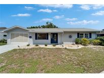 Charming single-story home with manicured lawn, light grey paint, and blue shutters at 1813 Allegheny Dr, Sun City Center, FL 33573
