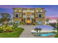 Stunning multi-story home showcasing unique architectural details, pristine landscaping, and a private pool with water views at 3236 Gulf Winds Cir, Hernando Beach, FL 34607