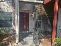 Inviting townhouse front door with screen door and lovely garden view at 3455 Countryside Blvd # 33, Clearwater, FL 33761
