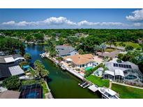 Beautiful waterfront home with a private dock and swimming pool and lush landscaping at 3691 Center Cir, Largo, FL 33774