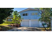 Two-story home featuring blue siding, white garage doors, and steps leading to the front entrance at 3717 Mckay Creek Dr, Largo, FL 33770