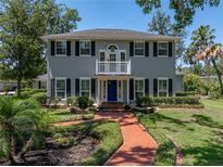 Charming two-story home with a brick walkway, blue door, and a balcony overlooking the landscaped front yard at 4611 Ackerly Way, Brandon, FL 33511