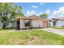 Charming single-story home featuring a well-maintained lawn and attached garage at 5115 Stonehaven Ct, Tampa, FL 33624