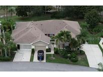 Charming single-story home features a well-manicured lawn, lush landscaping, and a two-car garage at 611 Tremont Greens Ln, Sun City Center, FL 33573