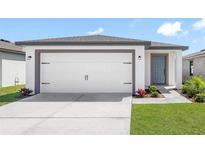 Charming single-Gathering home featuring a two-car garage, manicured lawn, and neutral color palette at 12074 Manassas Ave, Weeki Wachee, FL 34614