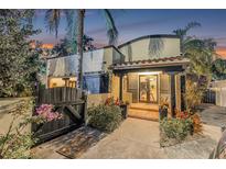 Inviting home exterior featuring a covered front entrance, lush landscaping, and unique architectural details at 122 Miramar Ne Blvd, St Petersburg, FL 33704