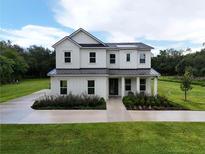 Charming two-story home with a well-manicured lawn, landscaping, and driveway at 2890 Alexandria Marie Ln, Lutz, FL 33559
