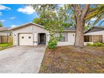 Charming single-Gathering home with neutral color palette, mature trees, and attached one-car garage at 2986 Cypress Green Dr, Palm Harbor, FL 34684