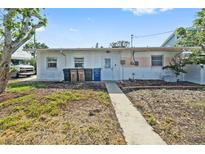 Modest backyard with a concrete path leading up to the back door of the home at 301 14Th Ave, Indian Rocks Beach, FL 33785