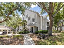 Charming two-story condo featuring a picnic table, lush landscaping, and covered parking at 3301 Haviland Ct # 203, Palm Harbor, FL 34684