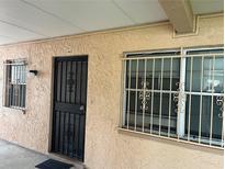 Exterior front door of unit 104, complete with decorative security door and window bars for added protection at 4708 Michael Ct # 104, Tampa, FL 33614
