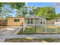 Charming single-story home with a fenced yard and driveway, showcasing its inviting curb appeal at 4735 W Leila Ave, Tampa, FL 33616