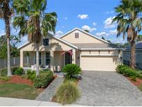Charming single-Gathering home with a two-car garage, well-manicured lawn and lush landscaping with palm trees at 5102 Coastal Scene Dr, Apollo Beach, FL 33572