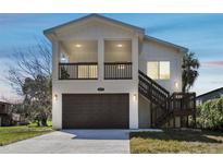 Inviting two-story home with a neutral color scheme, garage, and charming staircase leading to the main entrance at 6433 Werner Ave, New Port Richey, FL 34652